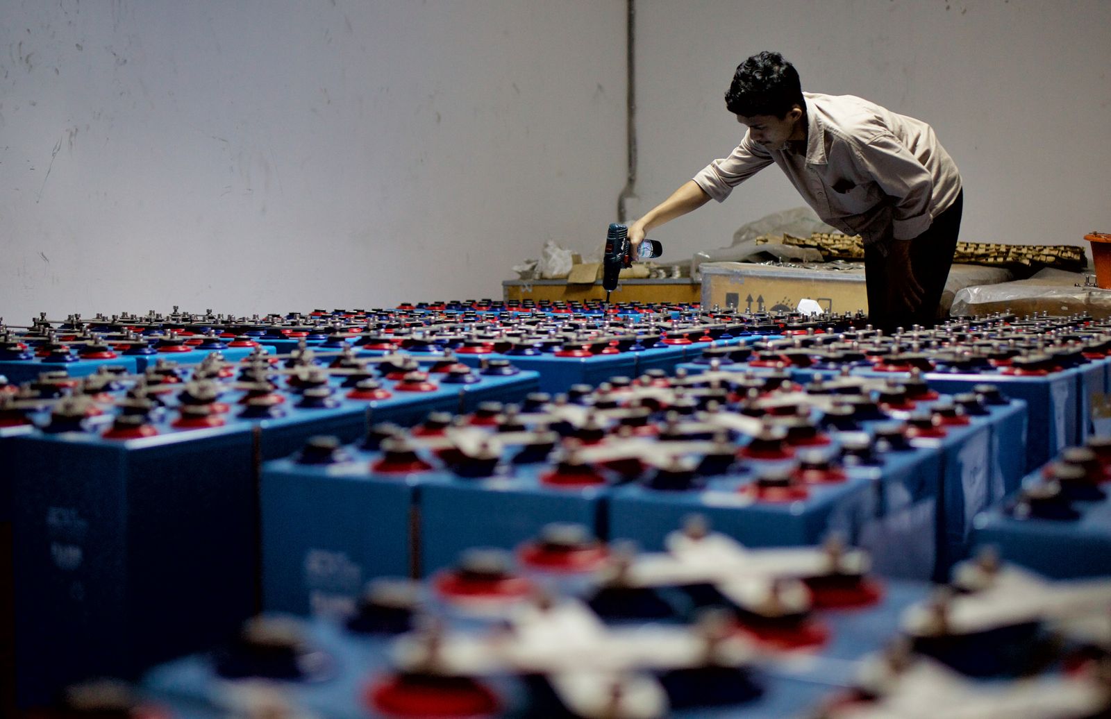 Technician inspecting an industrial battery bank