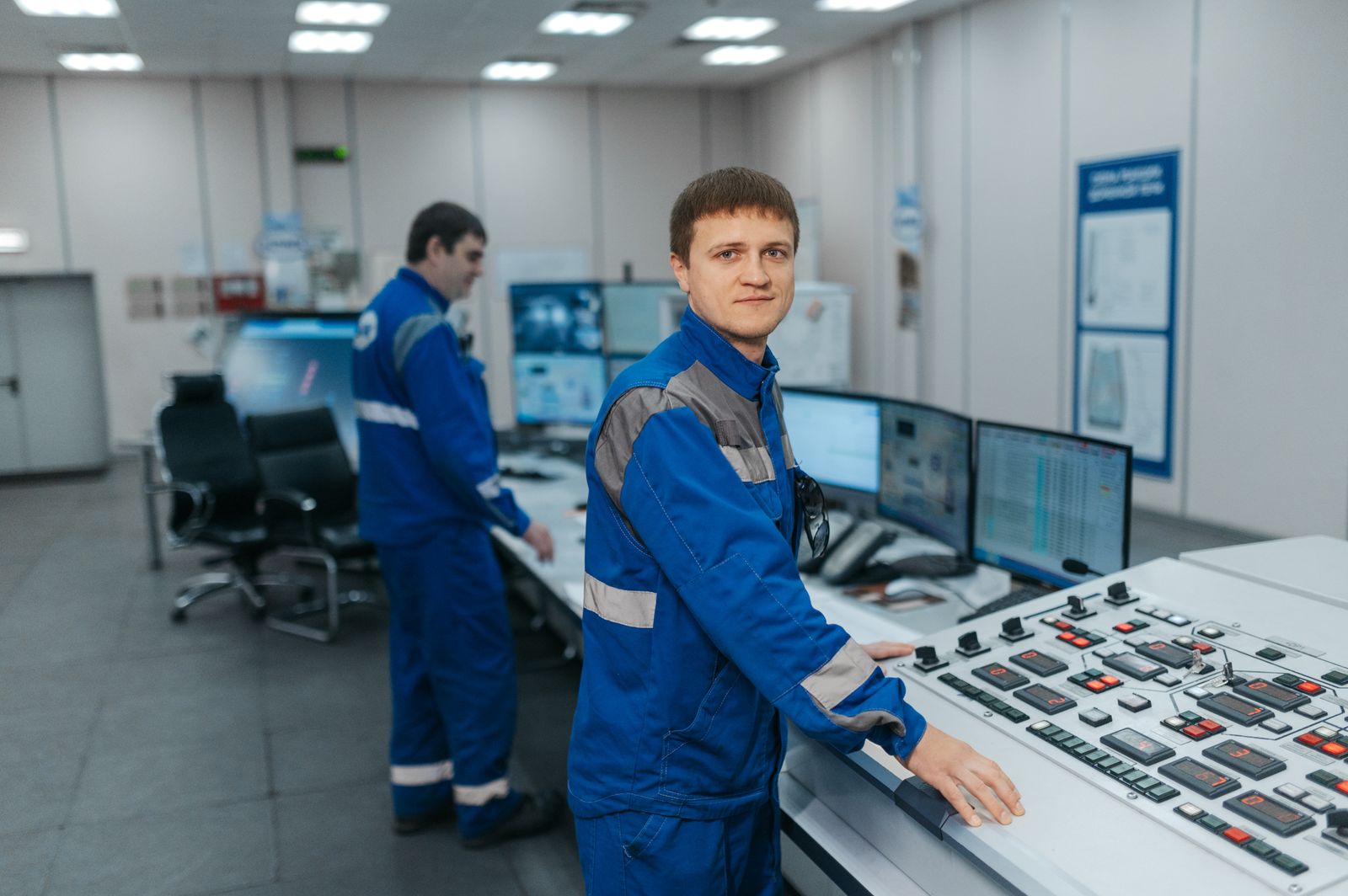 technicians in control room operating machinery