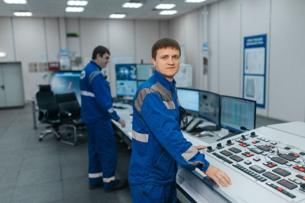 technicians in control room operating machinery